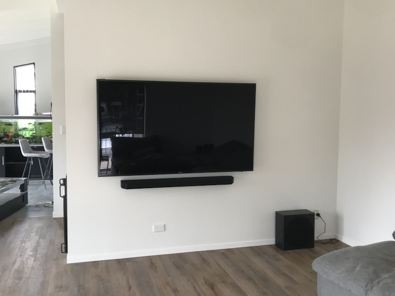 A TV and soundbar mounted together cleanly